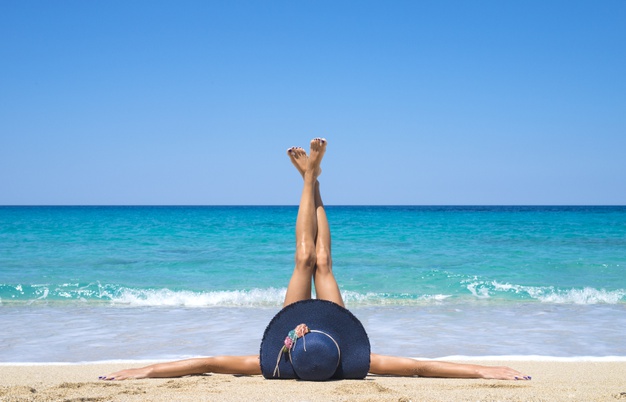 woman-lying-beach-with-legs-up-air_342744-549